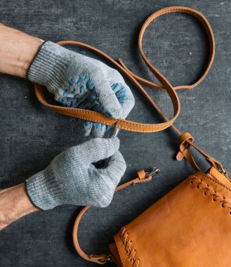 Atölyede çalışıyorum, bir zanaatkar deri kemerde bir delik açıyor.