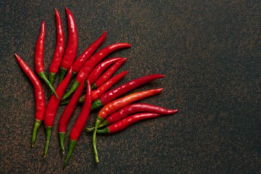 Koyu arkaplanda kırmızı kırmızı kırmızı biber ve fotokopi alanı. Üst görünüm