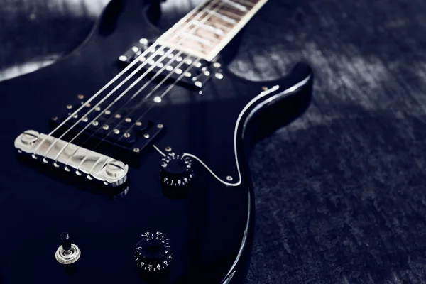 Siyah elektro gitarın makro görünümü, sinyal düzenleyici sapına seçici odaklanma, kopyalama alanı, düşük keskinlik derinliği