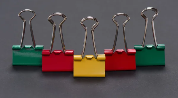 Colored binder clips on dark background — Stock Photo, Image