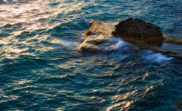 Ondas e pedra na composição da natureza por do sol — Fotografia de Stock