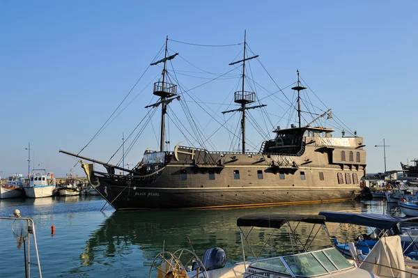 Chipre, barco de placer, una réplica de la famosa Perla Negra anclada rodeada de barcos de pesca en la bahía de Ayia Napa — Foto de Stock