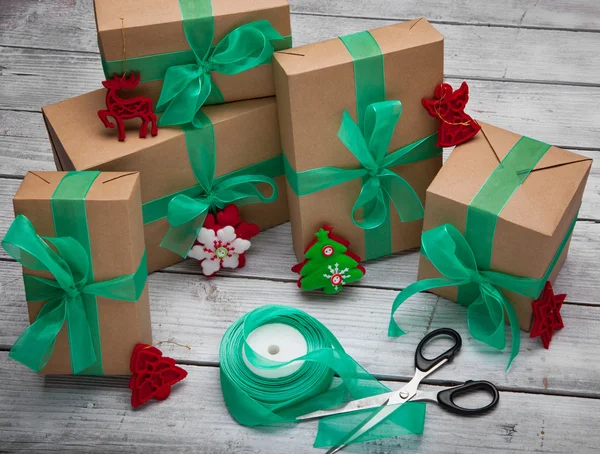 Boże Narodzenie prezenty pudełko prezentuje z brązowego papieru i wstążka zielony — Zdjęcie stockowe