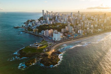 Brezilya 'nın Bahia Eyaleti' nde gün doğumunda Salvador Şehri ile Okyanustaki Kayadaki Barra Deniz Feneri 'nin Hava Görüntüsü