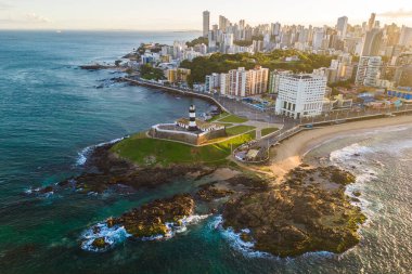 Brezilya 'nın Bahia Eyaleti' nde gün doğumunda Salvador Şehri ile Okyanustaki Kayadaki Barra Deniz Feneri 'nin Hava Görüntüsü