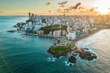 Brezilya 'nın Bahia Eyaleti' nde gün doğumunda Salvador Şehri ile Okyanustaki Kayadaki Barra Deniz Feneri 'nin Hava Görüntüsü