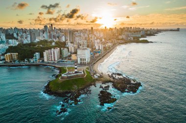 Brezilya 'nın Bahia Eyaleti' nde gün doğumunda Salvador Şehri ile Okyanustaki Kayadaki Barra Deniz Feneri 'nin Hava Görüntüsü