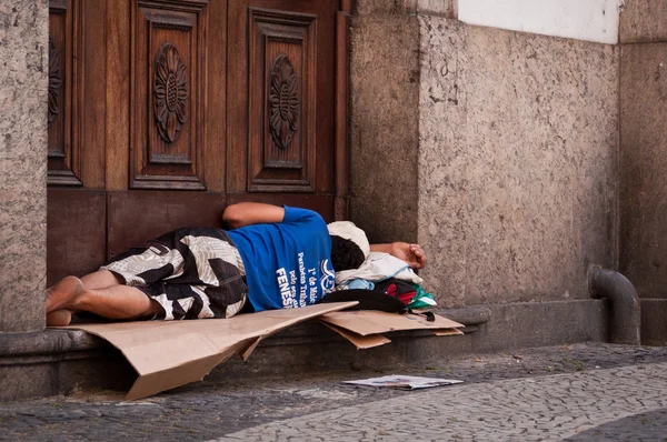 Bezdomny człowiek śpi w do wejścia do Kościoła — Zdjęcie stockowe