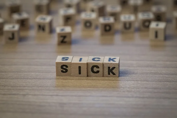 Doente escrito em cubos de madeira — Fotografia de Stock