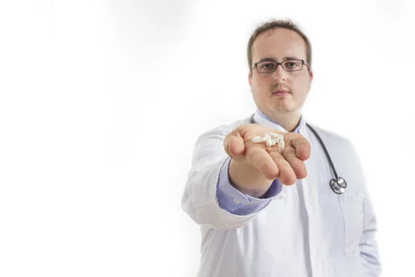 Jonge dokter uitdelen van pillen — Stockfoto