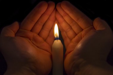 Hands protecting a Candle clipart
