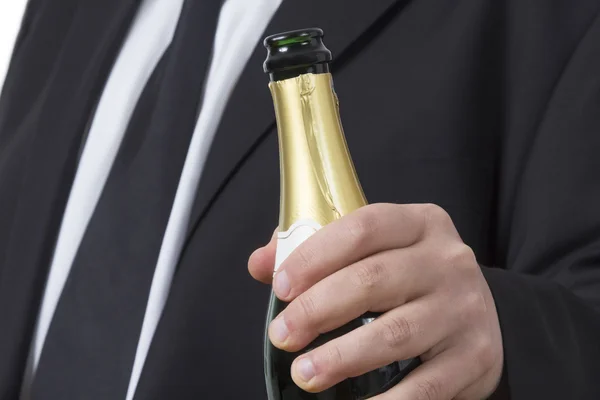 Человек в костюме с открытой бутылкой шампанского — стоковое фото