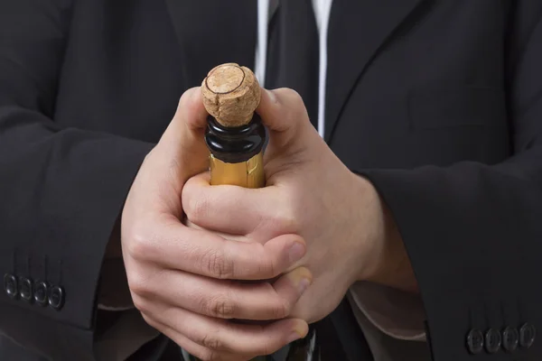 Man in siut opening Champagne bottle — Stock Photo, Image