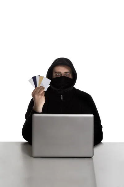 Hacker with credit cards on silver laptop — Stock Photo, Image