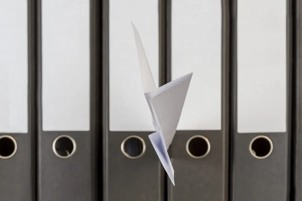 Papierowy samolot zatrzymany między folderami — Zdjęcie stockowe