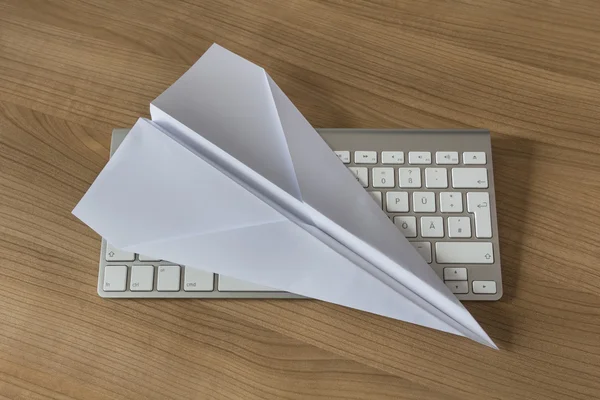 Бумажный самолет на рабочем столе — стоковое фото