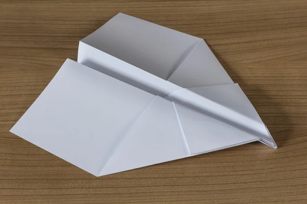 Papier vliegtuig op een houten tafel — Stockfoto