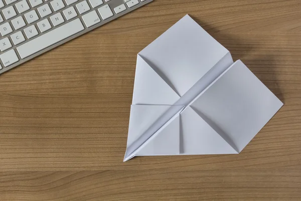 Avión de papel en un escritorio de oficina —  Fotos de Stock