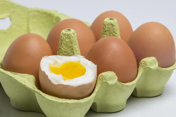 Box of Eggs with one broken boiled egg — Stock Photo, Image