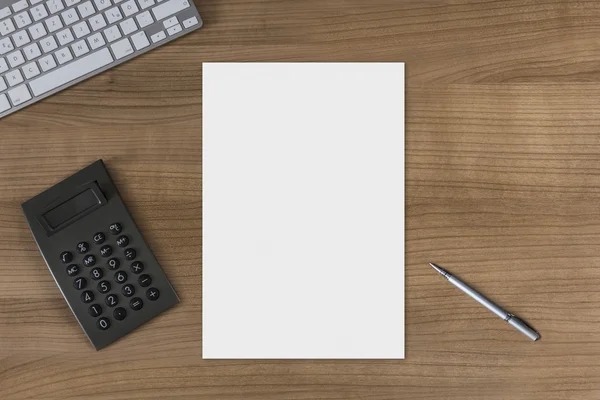 Sábana en blanco sobre una mesa de madera con calculadora — Foto de Stock