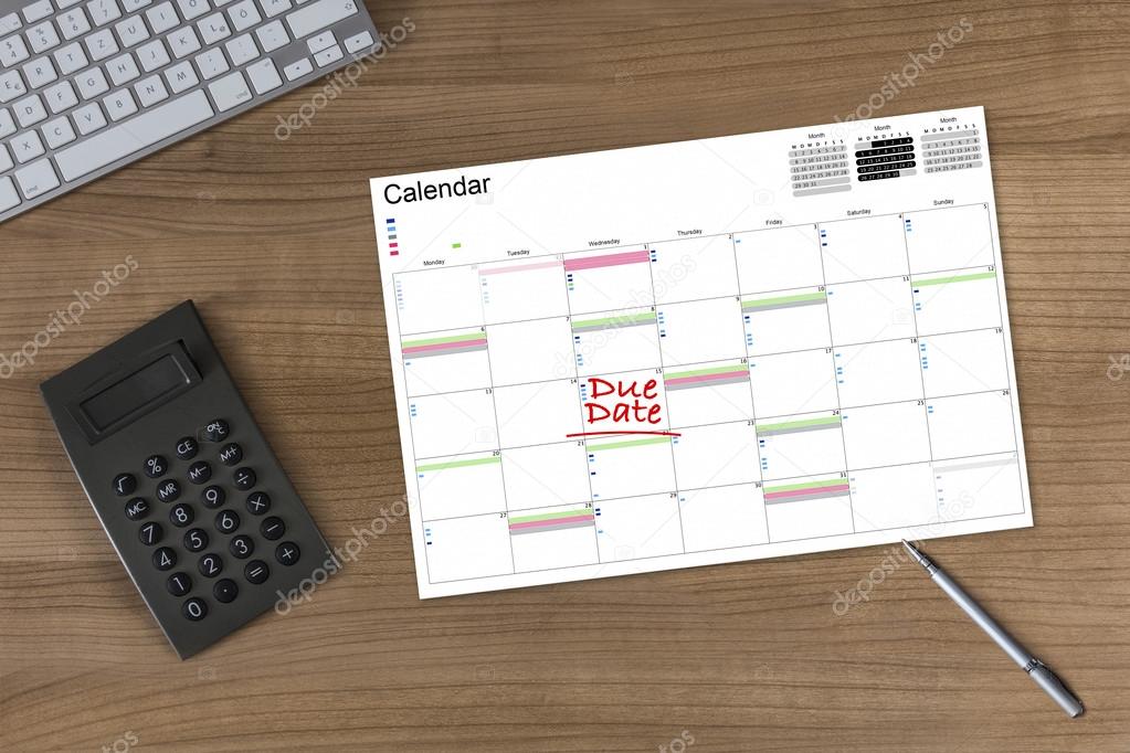 Calendar Due Date and Calculator on wooden Table