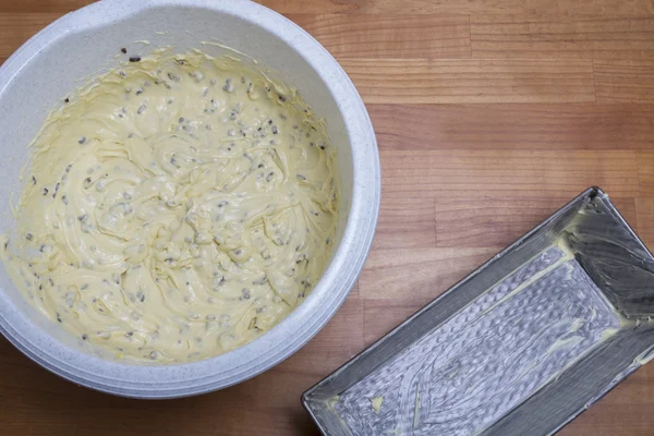 Dough in bowl and cake tin — Stock Photo, Image