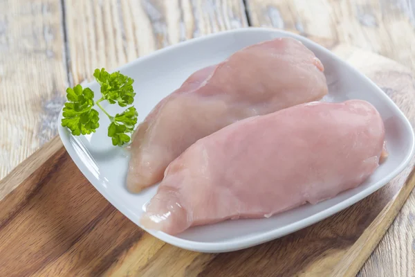 Peito de frango em tábua de madeira — Fotografia de Stock