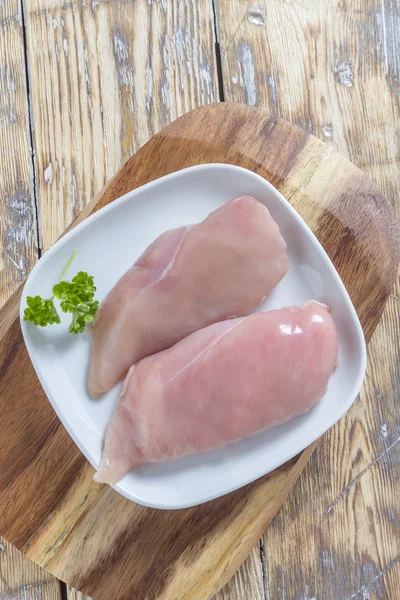 Peito de frango em tábua de madeira — Fotografia de Stock