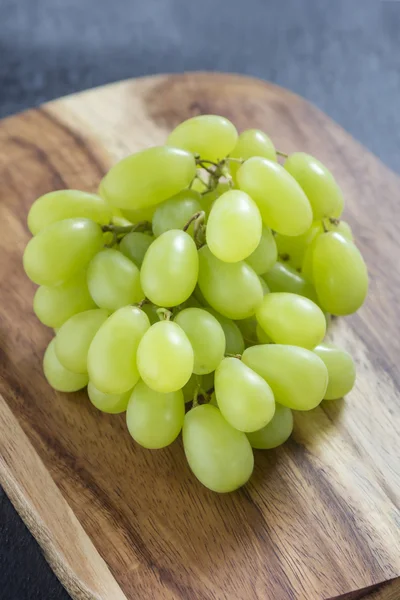 Uvas em tábua de madeira Imagem De Stock