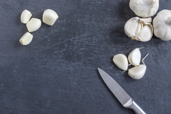 Lampadina di aglio e chiodi di garofano singoli su ardesia — Foto Stock