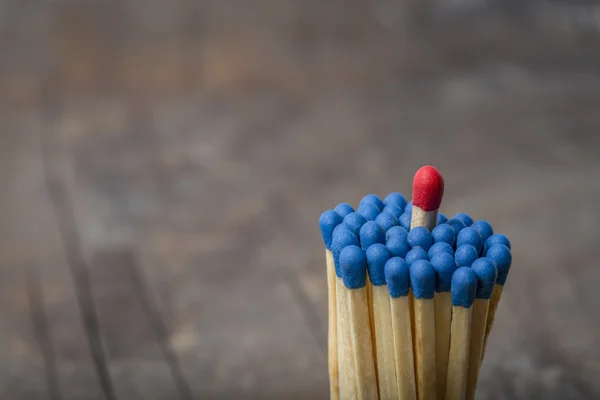 Röd Match i grupp av blå matcher — Stockfoto