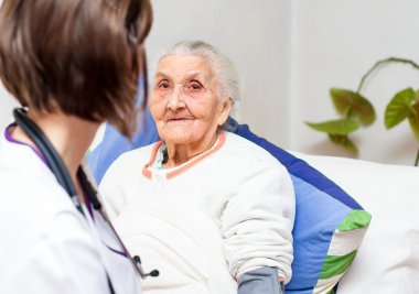 yaşlı kadın yatakta yatan bir genç hemşire bakım 