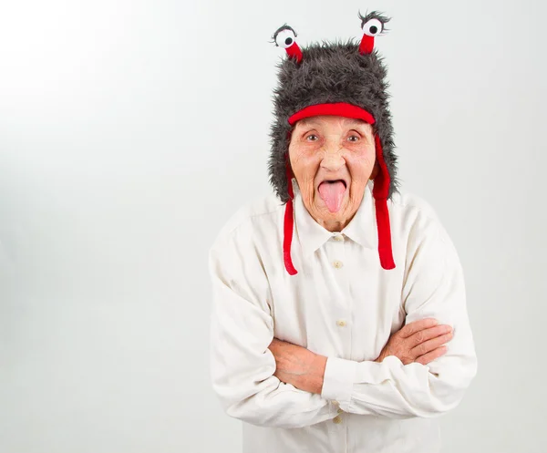 Abuela en divertido sombrero mostrando su lengua — Foto de Stock