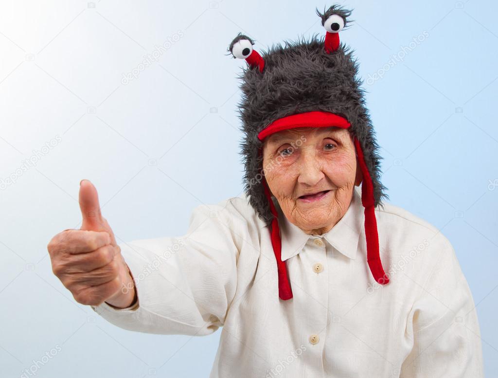 grandma in funny hat shows thumbs up