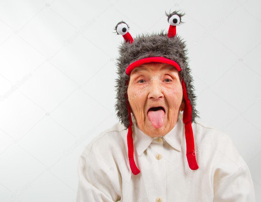 grandma in funny hat puts her tongue out