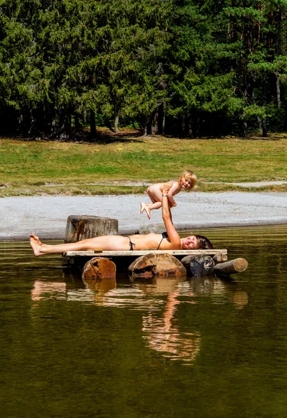 Молода мати зі своїм малюком на озері — стокове фото
