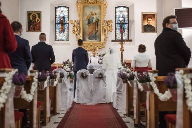CHOCIANOW, POLAND - 22 Ekim 2020. Sant Josef Kilisesi 'nde düğün. Covid-19 salgınından dolayı insanların yüz maskeleri ve sosyal mesafeleri var..