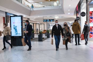 WROClaw, POLAND - 13 Aralık 2020. Alışveriş merkezindeki Wroclavia 'da yüz maskeli ve alışveriş çantalı insanlar..