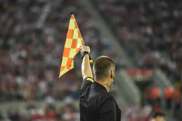 Assistant of football referee raise the flag up.