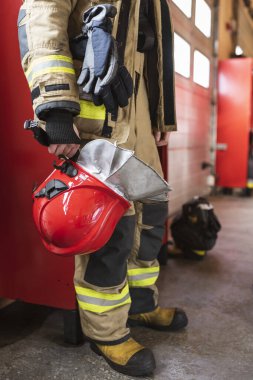 Kırmızı miğfer itfaiyecinin elinde.