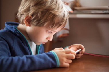 Genç tatlı çocuk kısa mesafeden akıllı telefon arıyor..