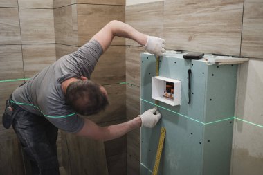 tiler banyodaki duvar fayanslarını düzenler.