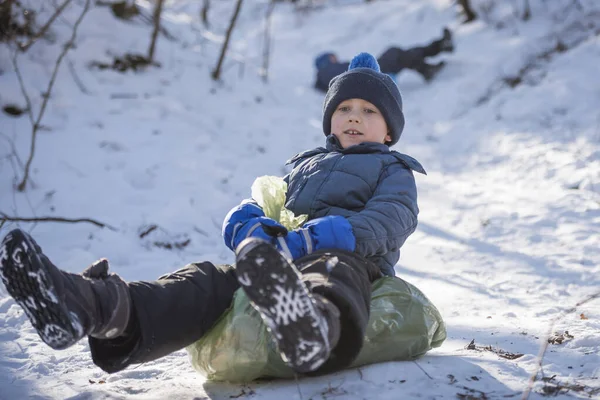 Νεαρό Αγόρι Κατεβαίνει Χιονισμένο Λόφο Μια Πλαστική Σακούλα — Φωτογραφία Αρχείου