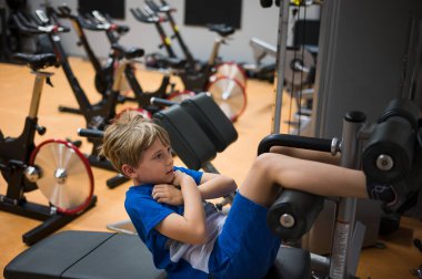 Genç çocuk profesyonel spor salonunda egzersiz yapıyor.