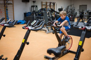 Genç çocuk profesyonel spor salonunda egzersiz yapıyor.