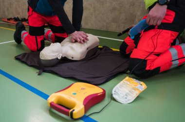 Manken ve defibrilatör kullanarak ilk yardım eğitimi sırasında sağlık görevlileri