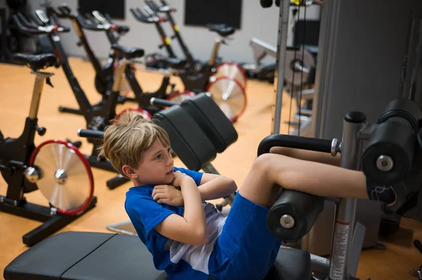 Genç çocuk profesyonel spor salonunda egzersiz yapıyor.