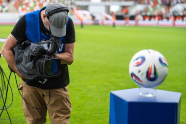 Futbol stadyumundaki kürsüde topu çeken kameraman.