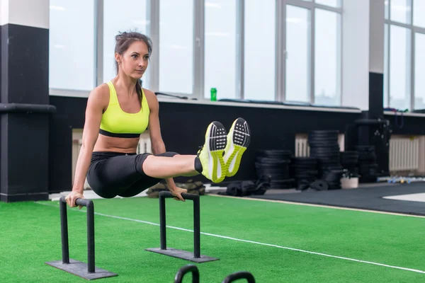 Женщина, занимающаяся L-сидячими тренировками в спортзале — стоковое фото