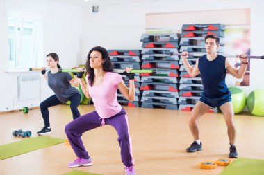 İnsanlar excercising çubuklarla grup  